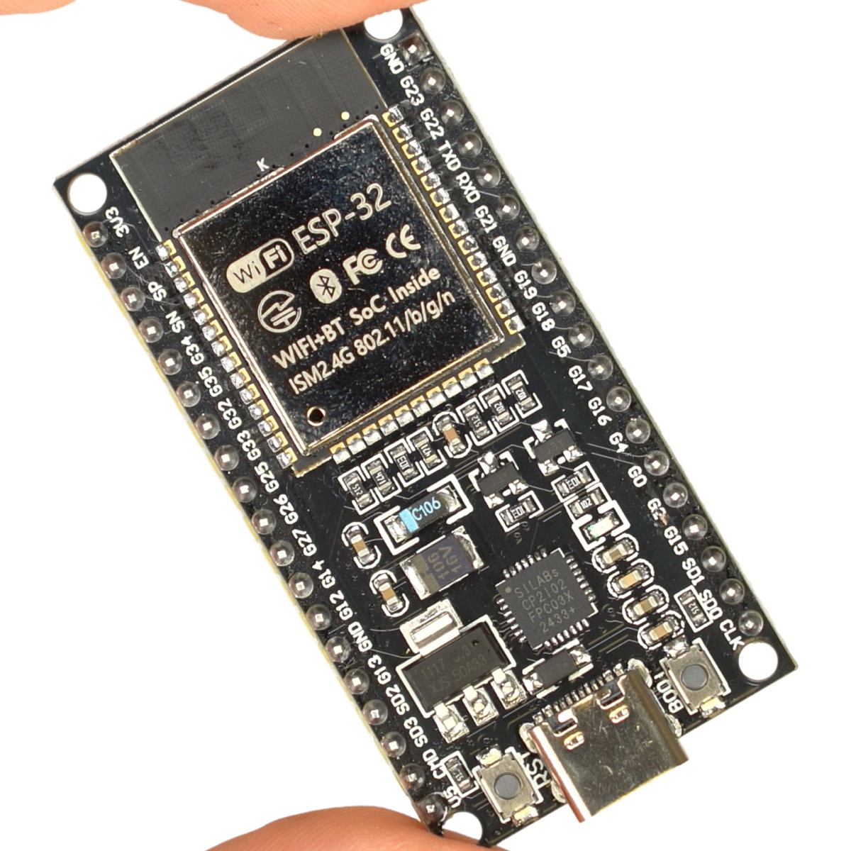 手持的经典款 ESP32 开发板，黑色 PCB 上印有 ESP-32 模组与 WiFi+BT SoC 丝印